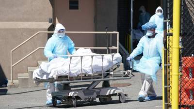 Bodies are moved to a refrigeration truck serving as a temporary morgue at Wyckoff Hospital in the Borough of Brooklyn on April 6, 2020 in New York. (Photo by Bryan R. Smith / AFP)