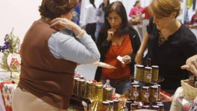 Waldina Bográn, periodista de profesión, muestra sus productos a dos clientes en potencia. Fotos: José Cantarero