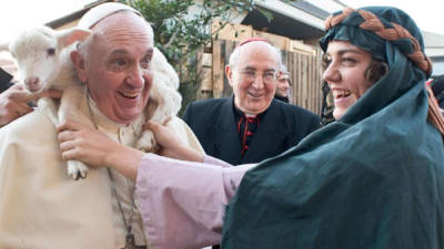 Fotografía facilitada por el diario vaticano L'Osservatore Romano hoy, martes 7 de enero de 2014, que muestra al papa Francisco sosteniendo un cordero sobre sus hombros durante una visita a un pesebre viviente con unos 200 figurantes, organizado por los fieles de la parroquia romana de San Alfonso de Ligouri, en Roma (Italia), el 6 de enero de 2014. EFE