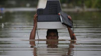 Con el agua al cuello en varios sectores del litoral atlántico de Honduras, los afectados por las lluvias buscaban salvar sus pertenencias.