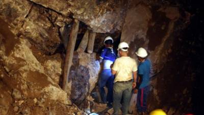 Tres mineros buscan a sus compañeros que quedaron atrapados el pasado martes en la mina La Cuculmeca en la zona sur de Honduras.