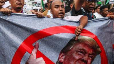Manifestantes sostienen una pancarta contra el presidente estadounidense, Donald Trump, durante una protesta frente a la embajada estadounidense en Kuala Lumpur (Malasia), hoy 15 de diciembre de 2017, en respuesta a la decisión de Trump de reconocer Jerusalén como la capital de Israel. EFE/ Fazry Ismail