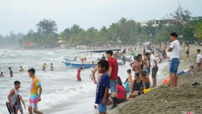 Pequeños disfrutaban de la arena y el agua en la playa municipal de Tela y muchos hacían fila para subir a las lanchas o a las famosas “bananas”.