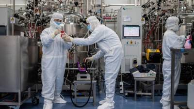 In this picture taken on April 29, 2020, engineers work on monkey kidney cells for an experimental vaccine for the COVID-19 coronavirus inside the Cells Culture Room laboratory at the Sinovac Biotech facilities in Beijing. - Sinovac Biotech, which is conducting one of the four clinical trials that have been authorised in China, has claimed great progress in its research and promising results among monkeys. (Photo by NICOLAS ASFOURI / AFP) / TO GO WITH Health-virus-China-vaccine,FOCUS by Patrick Baert