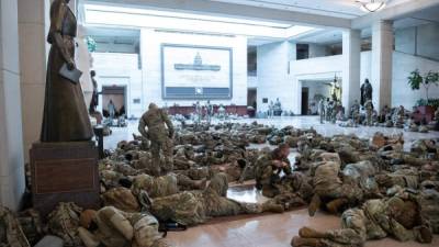 Miembros de la Guardia Nacional descansan en los pasillos del Congreso mientras se discute una sesión para iniciar juicio político, por segunda vez, al presidente saliente Donald Trump. FOTO AFP