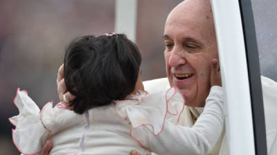 El papa Francisco saluda a una niña en la Plaza San Pedro en El Vaticano. AFP