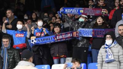 Los fanáticos del fútbol usan máscaras protectoras mientras asisten a los octavos de final de la UEFA Champions League entre el SSC Napoli y el FC Barcelona en el estadio San Paolo en Nápoles el 25 de febrero de 2020. Foto de archivo.