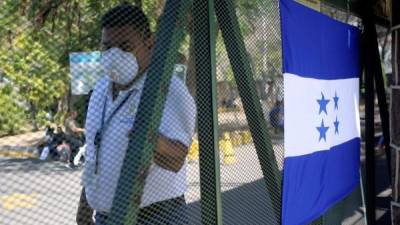 Un empleado público fue registrado el pasado jueves al cerrar la puerta del hospital donde se encuentra interna una de las hondureñas que se contagio con el COVID-19, en Tegucigalpa (Honduras). EFE/Gustavo Amador