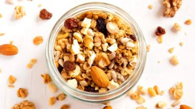 Homemade granola with nuts and seeds in glass jar for healthy breakfast