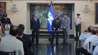 El presidente Juan Orlando Hernández en la firma del convenio entre el RAP y Banrural.