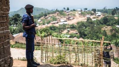 (FILES) This file photo taken on July 16, 2016 shows a Congolese policeman standing guard in the village of Buleusa.Tensions are high between Hutus and Kobos since the population started to return to the village after its evacuation by Rwandan Hutus Rebels (FDLR) in November 2015. At least 34 civilians were killed on November 27, 2016 in ethnic violence in restive eastern Democratic Republic of Congo, authorities said. / AFP PHOTO / Eduardo Soteras