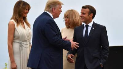 El presidente francés, Emmanuel Macron, saluda a su homólogo Donald Trump, al lado las primeras damas Melania Trump y Brigitte Macron.