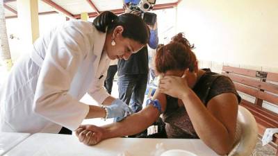 La doctora saca una muestra sanguínea a una paciente con sospecha de virus de chikunguña.
