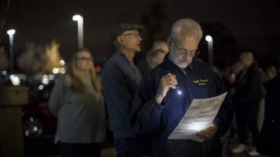 Chris Issariotis lee una papeleta de la muestra mientras que espera en línea para votar en la biblioteca del centro de la genealogía de Midwest en la independencia, Missouri, Estados Unidos. AFP