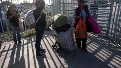 People walk back to Tijuana from San Diego at San Ysidro crossing port in Tijuana, Baja California state, Mexico, on April 2, 2019. - President Donald Trump said Tuesday he is '100 percent' prepared to close down the US-Mexico border, warning Congress and Central American governments to take action to stem the flow of migrants into the country. (Photo by Guillermo Arias / AFP)