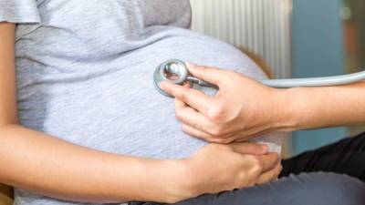 Hands of doctor examining a pregnant woman