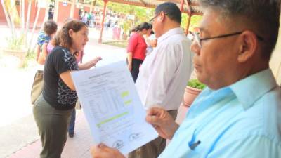 José Méndez ve las calificaciones de su hijo. Al fondo una madre reclama. Foto: Jorge Monzón