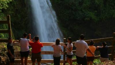 Turistas aprecian la caía de agua en Pulhapanzak, en Río Lindo, Cortés.