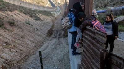 Fotografía de archivo de migrantes cruzando el cerco sobre la frontera México - Estados Unidos.