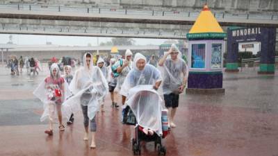 La gente abandona las intalaciones del parque temático de Disney World, cerca de Orlando, Florida, bajo la lluvia provocada por Matthew.
