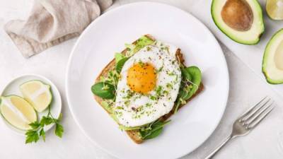 toast with avocado, spinach and fried egg, top view