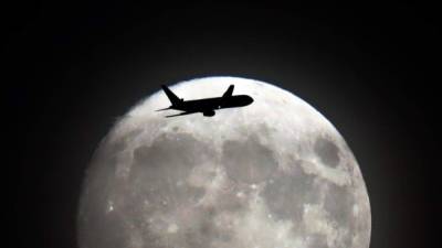 Este lunes 14 de noviembre se verá la Luna más grande y brillante desde el 25 de enero de 1948. En algunas partes del mundo ya la disfrutan. Un jet vuela frente a la luna en su acercamiento al aeropuerto de Heathrow en el oeste de Londres. AFP