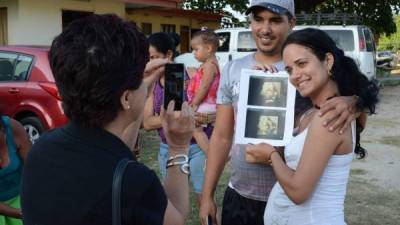 una pareja cubana es fotografiada mientras posa con el ultrasonido que muestra una nueva vida que se forma en el vientre materno. Ellos son parte de los varados en el refugio de la iglesia metodista en liberia. Fotos: AFP