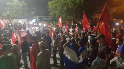 Decenas de manifestantes gritaron y agitaron sus banderas rojas.