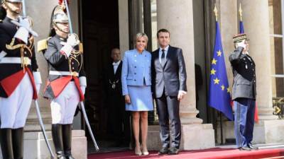 El presidente recién electo francés Emmanuel Macron (R) se presenta con su esposa Brigitte Trogneux en el Palacio Presidencial del Elíseo después de la entrega y antes de la ceremonia de inauguración.