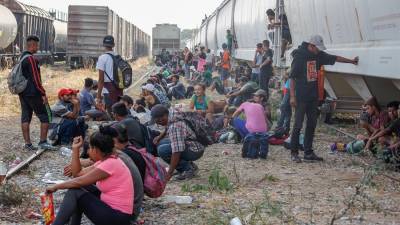 Migrantes centroamericanos esperan abordar las góndolas del tren “La Bestia”.