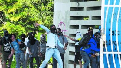 Students of the National Autonomous University of Honduras (UNAH) clash with riot police as they protest in demand of a reduction in the price of fuel in Tegucigalpa on July 25, 2018.Students joined transport unions -which threaten with going again on strike- demanding the government that the price of fuel be reduced. / AFP PHOTO / ORLANDO SIERRA