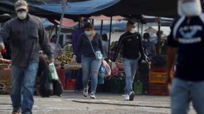 Hondureños realizan compras en un mercado de Tegucigalpa. Foto EFE