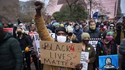 MINNEAPOLIS, MINNESOTA - APRIL 19: Demonstrators protest near the Hennepin County Courthouse on April 19, 2021 in Minneapolis, Minnesota. The jury began deliberating today at the courthouse in the trial of Derek Chauvin, a former Minneapolis police officer accused of killing George Floyd while detaining him on May 25, 2020, Floyd's death sparked outrage, protests and riots around the globe. Scott Olson/Getty Images/AFP== FOR NEWSPAPERS, INTERNET, TELCOS & TELEVISION USE ONLY ==