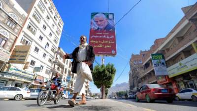 Un hombre yemení camina bajo un cartel del comandante militar iraní asesinado Qasem Soleimani en la capital, Sanaa, el 8 de enero de 2020. Soleimani y el jefe paramilitar iraquí Abu Mahdi al-Muhandis murieron en un ataque con aviones no tripulados estadounidenses cerca del aeropuerto internacional de Bagdad el 3 de enero. , provocando furia en Irán e Irak. / AFP / Mohammed HUWAIS