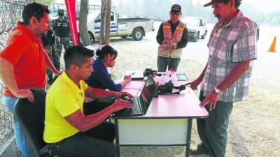 Personal de Transporte mientras hace el registro de los dueños de buses.