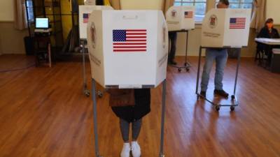 Los votantes se paran en las cabinas de votación antes de emitir boletas de papel en un lugar de votación en la Old Stone School en Hillsboro, Virginia. EFE