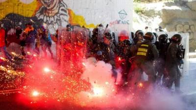 - Integrantes de la Guardia Nacional Bolivariana (GNB) se protegen durante enfrentamientos con manifestantes opositores al gobierno del presidente Nicolás Maduro durante una protesta hoy, sábado 12 de abril del 2014, en el sector de Bello Monte en Caracas (Venezuela).