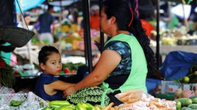 Una madre y su hija venden hortalizas en un mercado este 11 de mayo de 2019 en Tegucigalpa.