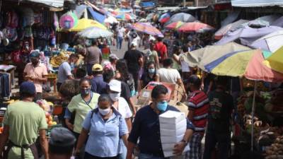 Personas comprando en un mercado en Tegucigalpa durante el primer día de la apertura.