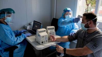 Un trabajador de la salud toma la temperatura a un paciente en una clínica de San José. Costa Rica a visto un notable aumento de contagios en los últimos días.