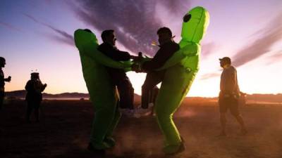 Personas en traje de baile ayer durante un DJ en 'Alienstock' en Rachel, Nevada, EE UU. Comenzando como una broma, el evento 'Storm Area 51' se transformó en una reunión para creyentes alienígenas, con música y atracciones en varios lugares alrededor del Área 51. EFE/EPA/Etienne Laurent