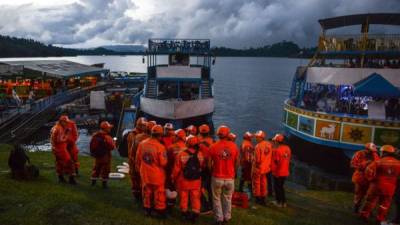 Rescue officials gather to take part in a search for survivors after the tourist boat Almirante sank in the Reservoir of Penol in Guatape municipality in Antioquia on June 25, 2017.At least nine people were dead and 28 missing after a tourist boat sank for unknown reasons in a reservoir in Colombia Sunday, authorities said, sharply raising an earlier toll. / AFP PHOTO / JOAQUIN SARMIENTO