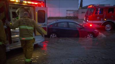 SUN VALLEY, CA - FEBRUARY 17: Firefighters prepare to transport a patient by ambulance at the scene of a car stuck in flooding as a powerful storm moves across Southern California on February 17, 2017 in Sun Valley, California. After years of severe drought, heavy winter rains have come to the state, and with them, the issuance of flash flood watches in Santa Barbara, Ventura and Los Angeles counties, and the evacuation of hundreds of residents from Duarte, California for fear of flash flooding from area denuded by a wildfire last year. David McNew/Getty Images/AFP== FOR NEWSPAPERS, INTERNET, TELCOS & TELEVISION USE ONLY ==