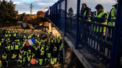 'Yellow Vest' (Gilets Jaunes in French) protesters take part in a demonstration on the A6 motorway in Villefranche-sur-Saone on November 24, 2018, to protest against high fuel prices and living costs. - Demonstrators who have blocked French roads over the past week dressed in high-visibility jackets, were set to cause another day of disruption on November 24 amid calls to bring Paris to a standstill. Anti-government protesters clashed with French police on the Champs-Elysees in Paris, leaving the famed avenue cloaked in tear gas on a fresh day of demonstrations against the president. (Photo by JEFF PACHOUD / AFP)