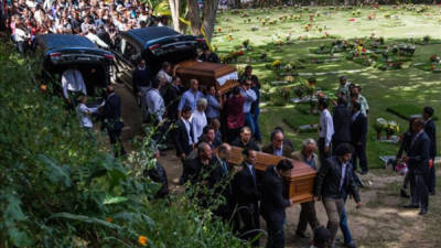 Un grupo de personas fue registrado este viernes al cargar el féretro de la exMiss Venezuela Mónica Spear (adelante) y de su esposo Henry Thomas Berry (atrás), durante su funeral en el Cementerio del Este, en Caracas (Venezuela). EFE
