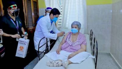 Doña Julia Contreras residente en el barrio San Cristóbal, de San Pedro Sula, fue la primera en ser vacunada contra el covid en su casa, padece de varias enfermedades y no puede caminar.Fotos: Moisés Valenzuela.