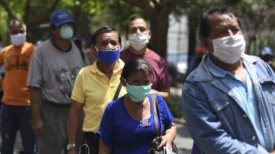 Personas se protegen con una mascarilla para evitar el contagio del coronavirus. Foto: AFP