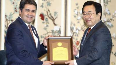 El presidente hondureño, Juan Orlando Hernández, recibe el título de ciudadano honorario de manos del alcalde de Busan, Suh Byung-soo, durante un acto celebrado en la ciudad portuaria de Busan (Corea del Sur). EFE