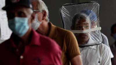 Zaul Ortega, de 53 años, se cubre el rostro con una bolsa plástico mientras hace fila para comprar en un supermercado durante la pandemia del coronavirus, en Ciudad de Panamá (Panamá). EFE/Bienvenido Velasco/Archivo