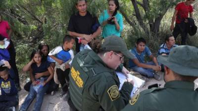 MCALLEN, TX - JUNE 12: Central American asylum seekers wait as U.S. Border Patrol agents take groups of them into custody on June 12, 2018 near McAllen, Texas. The families were then sent to a U.S. Customs and Border Protection (CBP) processing center for possible separation. U.S. border authorities are executing the Trump administration's zero tolerance policy towards undocumented immigrants. U.S. Attorney General Jeff Sessions also said that domestic and gang violence in immigrants' country of origin would no longer qualify them for political-asylum status. John Moore/Getty Images/AFP== FOR NEWSPAPERS, INTERNET, TELCOS & TELEVISION USE ONLY ==